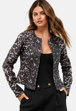 Jacke mit Leopardenmuster in Schwarz und Grau, mit Rundhalsausschnitt, tailliertem Schnitt und langen Ärmeln, getragen über einem schwarzen Oberteil.