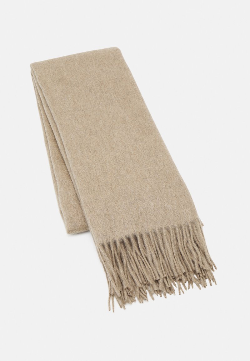 Écharpe en laine beige pliée avec des extrémités à franges sur fond blanc.