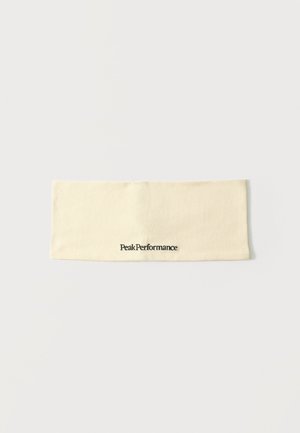 Bandeau en tissu couleur crème avec le logo "Peak Performance" brodé en noir au centre.