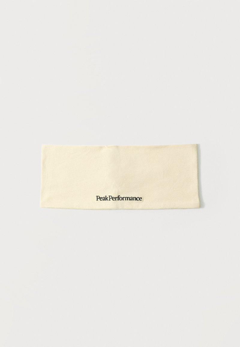 Bandeau en tissu couleur crème avec le logo "Peak Performance" brodé en noir au centre.