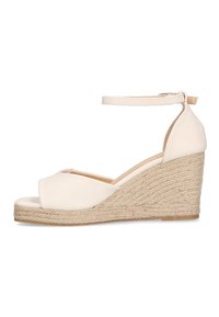 Sandalias de cuña beige con tacón de yute trenzado, punta abierta, tira al tobillo y parte superior de cuero suave. Diseño minimalista y color neutro.