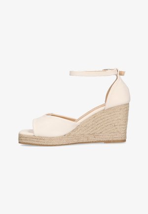 Sandalias de cuña beige con tacón de yute trenzado, punta abierta, tira al tobillo y parte superior de cuero suave. Diseño minimalista y color neutro.