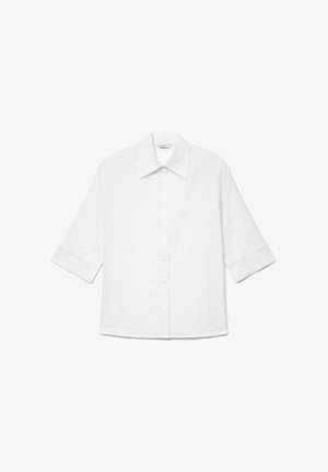 Weiße Bluse zum Knöpfen mit 3/4-Ärmeln, spitzem Kragen und dezentem Blumenstickmuster auf leichtem Stoff.