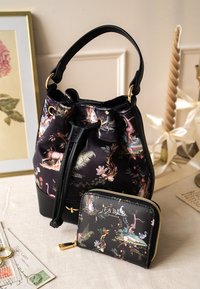 Mustakukkaro, jossa on kukkakuosi vaaleanpunaisen ja vihreän sävyissä, ja joka on varustettu nyörikiinnityksellä. Mukana yhteensopiva vetoketjupenni.