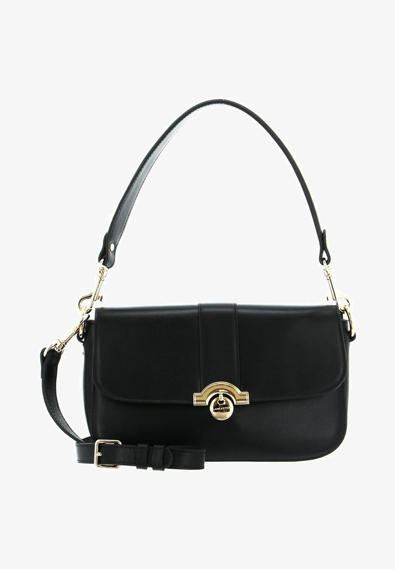 Sac à main en cuir noir avec un fermoir circulaire doré, bandoulière réglable, texture lisse et design structuré, avec un rabat pliable.