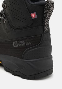 Schwarzer Wanderschuh mit textilem Obermaterial, Gummisohle und Mesh-Akzenten. Mit Jack Wolfskin-Logo und Primaloft-Label an der Ferse.