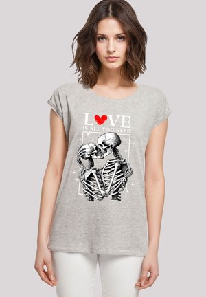 Gray short-sleeve t-shirt featuring a graphic of two skeletons embracing, with the text "LOVE IS ALL YOU NEED" and a red heart accent.