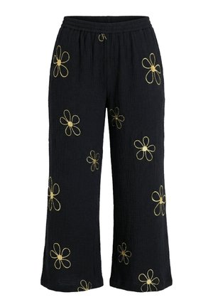 Czarne szerokie spodnie z elastycznym pasem i żółtymi haftowanymi wzorami stokrotek rozrzuconymi na materiale.