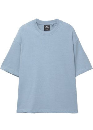 Lyseblå oversized t-shirt med korte ærmer og rund hals, med synlig mærkeetiket inden i kraven, præsenteret på hvid baggrund.