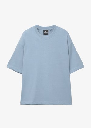 T-shirt azzurro chiaro oversize a maniche corte con colletto rotondo e etichetta del marchio visibile all'interno del colletto, esposto su uno sfondo bianco.