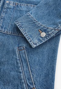 Giubbotto in denim di blu chiaro con cuciture a contrasto. Caratterizzato da un colletto a bavero, chiusura con bottoni e una tasca laterale. Texture morbida.