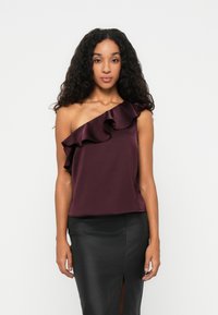 Burgundy satin topp med en axel och volangdetalj. Enkel snitt med en mjuk textur, paras med en åtsittande svart kjol med en slits.