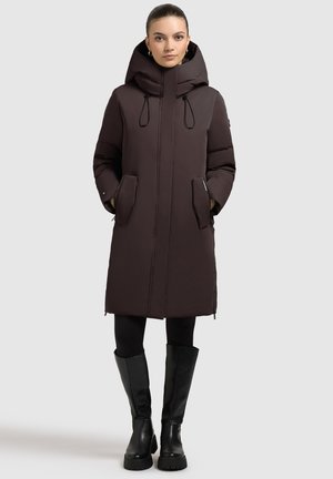 Palton maro căptușit cu glugă, buzunare laterale și fermoar pe toată lungimea. Purta peste colanți negri și cizme negre până la genunchi.