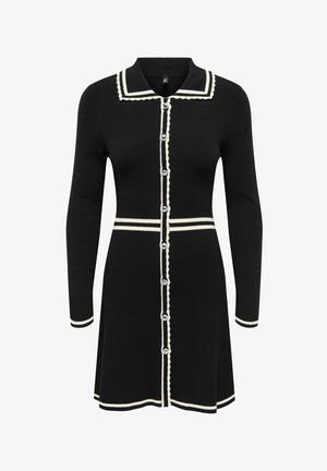 Černé pletené šaty s dlouhými rukávy a bílými detaily, knoflíková léga, vroubkované okraje a límec ve stylu námořníka.