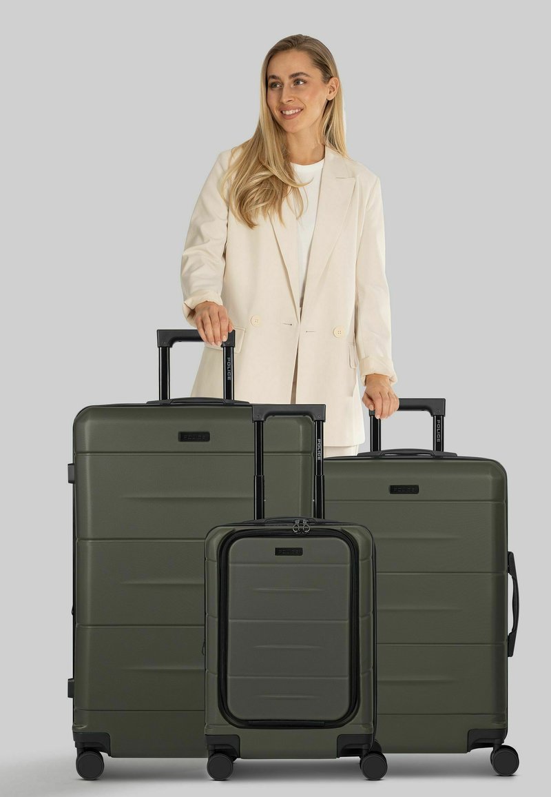 Set di valigie verde scuro in tre pezzi con finitura testurizzata, maniglie nere e ruote lisce. Le dimensioni variano dal piccolo bagaglio a mano alla valigia grande.