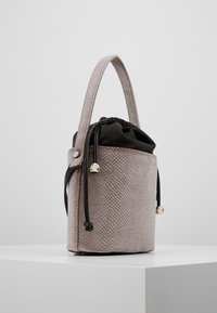 Mała, okrągła torba o teksturowanej, jasnoszarej powierzchni, czarne zamknięcie na ściągacz z tkaniny oraz krótka rączka. Srebrne akcenty na elementach metalowych.