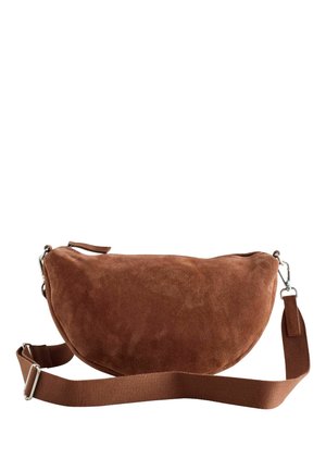 Bruine suède schoudertas in halve maantjesvorm met verstelbare stoffen riem en zilverkleurige metalen gespen.