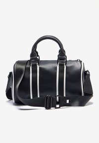 Juodos odos rankinė su faktūruotu paviršiumi, turinti du viršutinius rankenėles ir nuimamą dirželį, išryškinta baltomis juostelėmis ir sagties užsegimu.