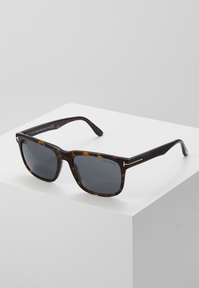 Tortoiseshell sunglasses with dark lenses, square shape, and metal accents on the temples. Logo on the inner side of the frame.