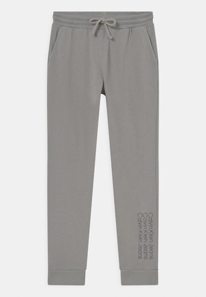 Hellgraue Sweatpants mit elastischem Bund und verstellbarem Kordelzug. Mit Seitentaschen und "Calvin Klein Jeans"-Druck entlang des Beins.