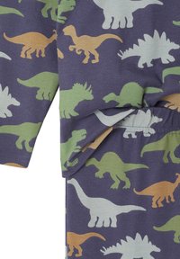 Baumwoll-Pyjama-Set mit einem dunkelvioletten Hintergrund, auf dem verschiedene Dinosauriersilhouetten in Grün, Creme und Beige zu sehen sind, was ein verspieltes Design zeigt.