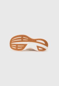 Semelle de chaussure en caoutchouc tan avec des rainures texturées, présentant une semelle intermédiaire blanche. Le design comprend des lignes courbes et des sections découpées pour plus de flexibilité.
