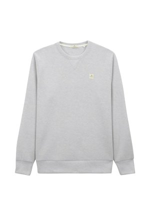 Sweatshirt gris en tissu doux, avec un col rond, des poignets côtelés et un petit patch logo sur la poitrine gauche.