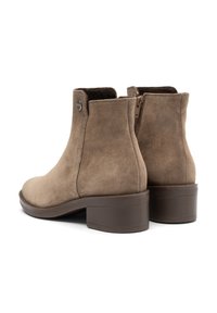 Bottines en suède marron avec un petit talon carré. Comprend une fermeture éclair et un bout rond avec un intérieur doublé en tissu doux.