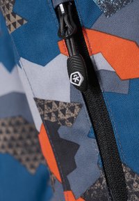 Bunt gemusterter Stoff mit geometrischen Mustern in Blau, Grau, Orange und Schwarz. Verfügt über einen schwarzen Reißverschluss mit einem strukturierten Ziehfänger.