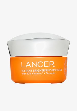 Oranje potje Lancer Instant Brightening Booster huidverzorging met zilveren deksel, met op de voorkant tekst over 30% vitamine C en kurkuma.