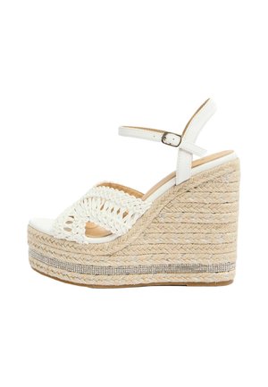 White wedge sandal with braided jute platform, ankle strap with buckle, and crochet-style front band, featuring a rhinestone trim around the sole.