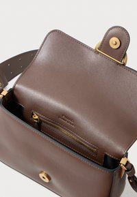 Bolso de hombro de cuero marrón con bolsillo interior de cremallera en tono dorado y cierre de imán, con la marca "Pinko Genuine Leather."
