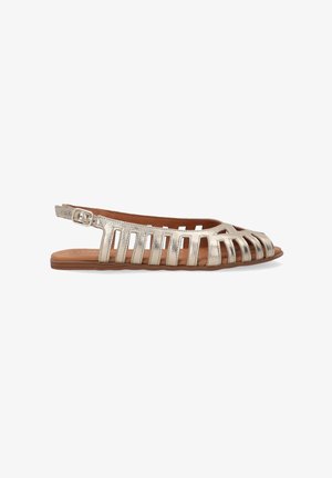 Metallic silver flat sandals with an open design, featuring cut-out straps and an adjustable buckle at the ankle. Brown insole.