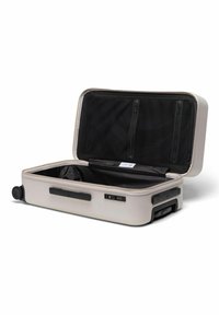 Hartschalenkoffer in hellbeige, mit Reißverschluss, schwarzen Netzfächern und zwei Rollen für Mobilität.