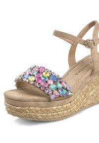 Beige wedge sandal made of suede with multicolored gem embellishments across the strap and a braided jute midsole.