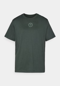 Mørkegrøn kortærmet T-shirt med lille Chelsea Football Club-logo centralt på brystet og subtil Nike swoosh på venstre ærme.