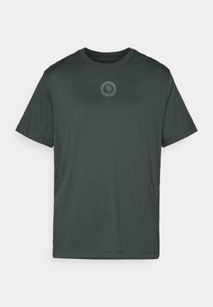 Tamsiai žalia trumpa rankovė T-shirt su mažu Čelsio futbolo klubo logotipu, kuris yra centre ant krūtinės, ir subtiliu "Nike" logotipu ant kairės rankovės.