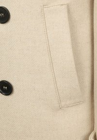 Beige wollen jas met een gestructureerde stof, een zwarte knoopsluiting en een zijzak met nette stiksels.