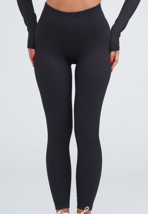 Svarta ribbade leggings med hög midja. Slät textur och figurnära design som sträcker sig till anklarna med en diskret logotypdetalj.