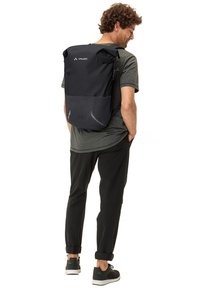 Mochila negra tipo roll-top con correas ajustables, tejido texturizado y detalles reflectantes. Incluye un bolsillo delantero y un diseño ergonómico.