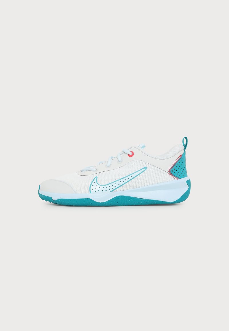 Λευκό και τιρκουάζ αθλητικό παπούτσι Nike με κορδόνια, διάτρητο λογότυπο Swoosh και τιρκουάζ σόλα σε απλό λευκό φόντο.
