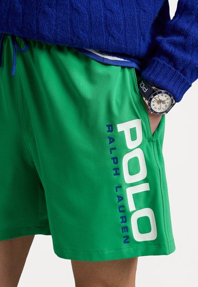 Shorts de bain verts avec un grand logo blanc "POLO" et le texte "RALPH LAUREN" en bleu, dotés d'une taille élastique et d'une poche latérale.