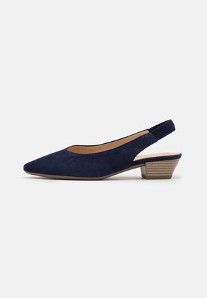 Navyblå ruskind slingback sko med spids tå og lav stakket klods hæl på hvid baggrund.