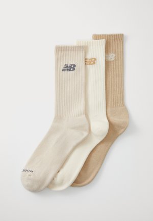 Set of three ribbed crew socks in beige, cream, and tan, featuring a logo near the cuff. Soft texture and solid colors with no patterns.