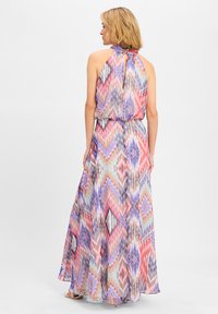 Abito lungo in tessuto leggero multicolore con scollatura a halter e motivo a zigzag. Presenta una vita cinchata e una gonna fluida.