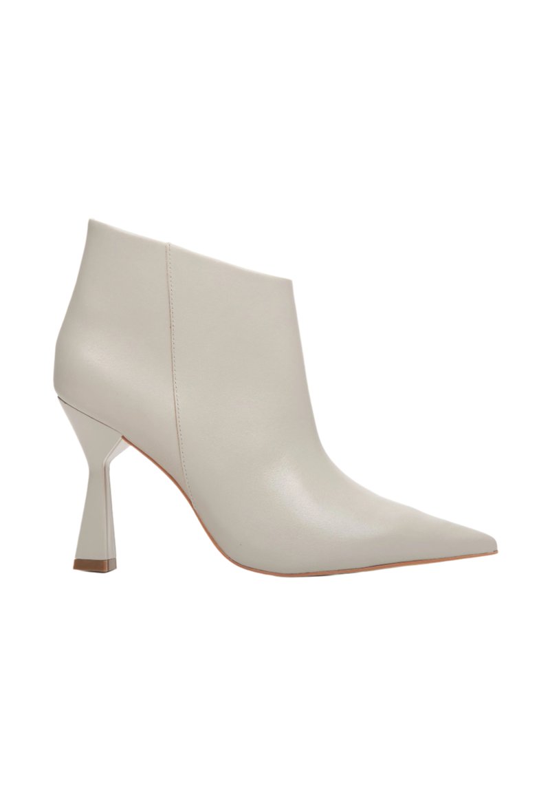 Beżowe skórzane botki za kostkę z ostrym noskiem i unikalnym kanciastym obcasem. Gładka tekstura z minimalnymi detalami przeszyć i elegancki kształt.