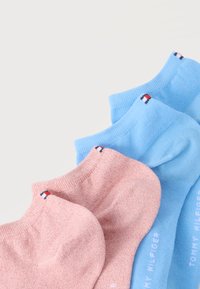 Δύο ζευγάρια καλτσάκια αστραγάλου, ένα ροζ και ένα ανοιχτό μπλε, το καθένα με ένα μικρό κόκκινο, άσπρο και ναυτικό λογότυπο κοντά στη μανσέτα.