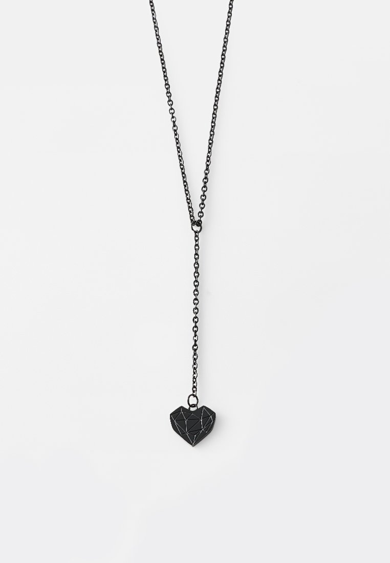 Czarny naszyjnik metalowy z geometrycznym wisiorkiem w kształcie serca, przymocowany do łańcuszka z ogniwami. Wisiorek ma teksturowaną powierzchnię i ostre kąty.