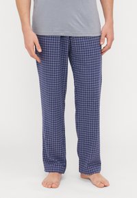Calças de pijama quadriculadas em azul-marinho, com um tecido macio, apresentando padrões de rede brancos. Corte solto e reto, adequadas para conforto.