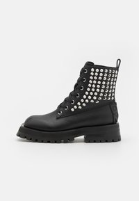 Cizme negre la gleznă cu un finisaj din piele netedă, având nituri argintii pe lateral, ochiuri metalice și o talpă masivă de tip lug.